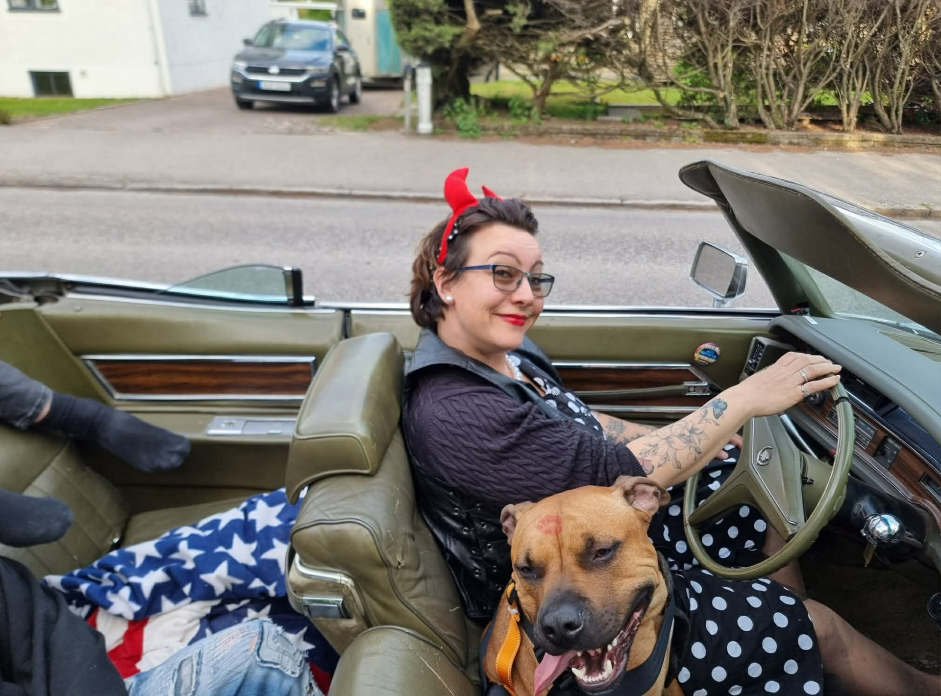 Bakom ratten i en Cadillac cabriolet med hunden i passagerarsätet