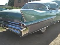 Grön Cadillac 1958 i profil med krom och höga fenor
