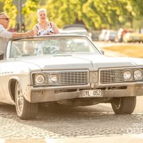 Vit cabriolet på studentkörning en solig dag