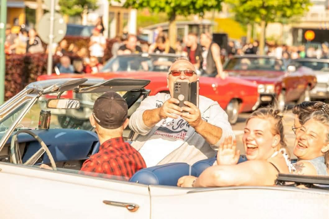 Glada passagerare i en öppen cabriolet på cruising