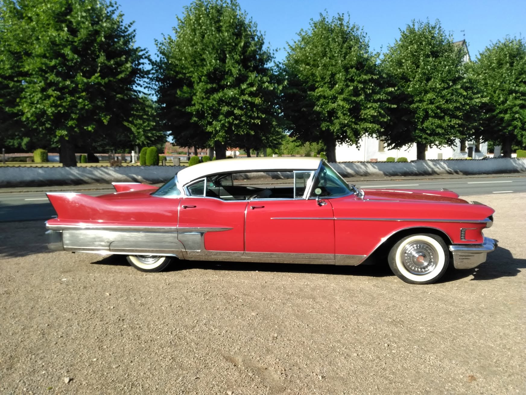 Röd Cadillac 1958 med vitt tak och vitsidesdäck